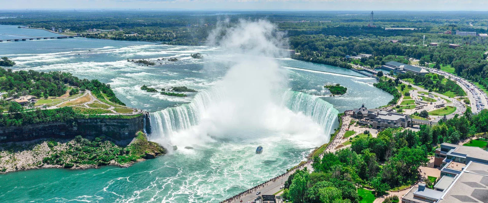 A tour boat sailing into the mist at the base of the Horseshoe Falls on the Canadian side of Niagara